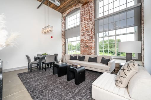 a living room with large windows and a couch and a table