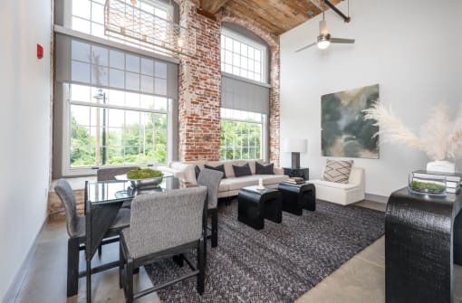 a living room with a large window and a table with chairs