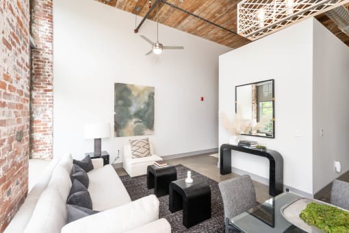 a living room with a white couch and a brick wall