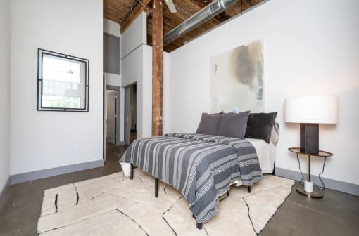 a bedroom with a bed and a exposed ceiling