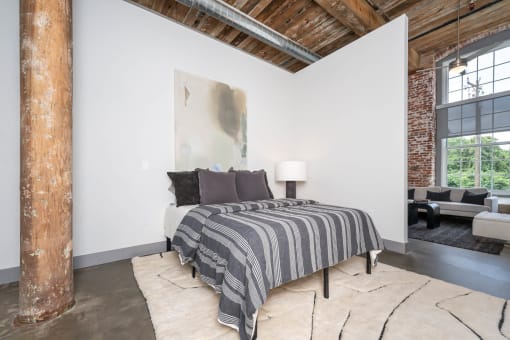 a bedroom with a bed and a exposed brick wall