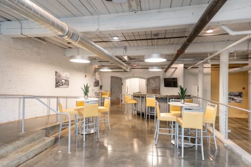 a large room with tables and chairs and a bar