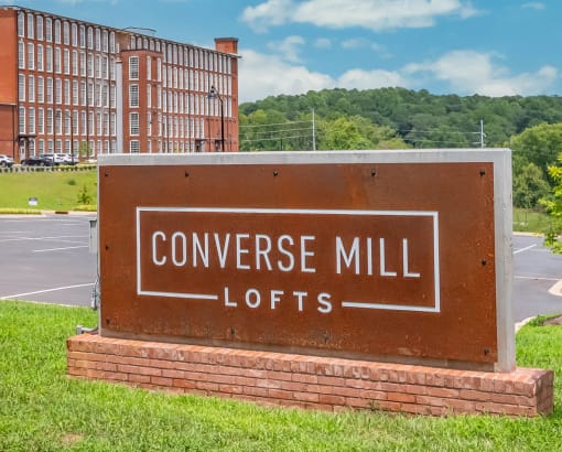 a sign that says converse mill lofts in front of a building
