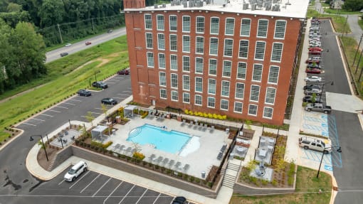 a building with a swimming pool in front of a parking lot