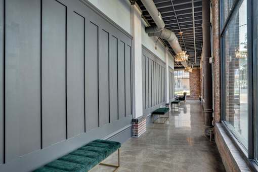 A long hallway with a bench and a window on the side.