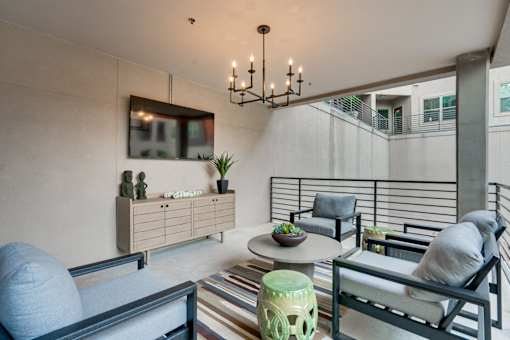 A modern living room with a striped rug and a black chair.