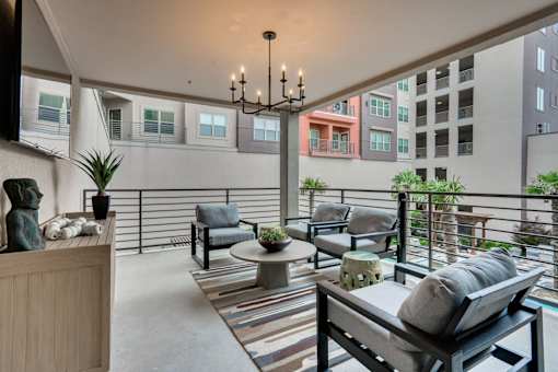 A balcony with a table and chairs and a potted plant.