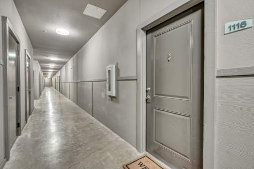 A long hallway with doors on both sides and a sign that says 1118.