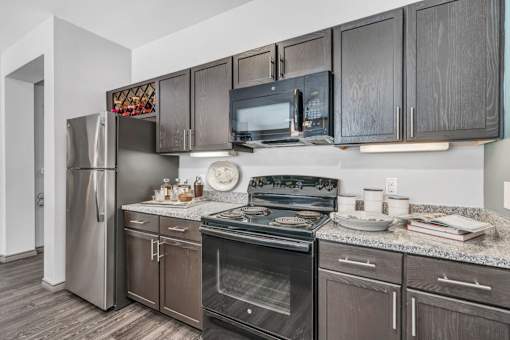 A kitchen with dark wood cabinets and stainless steel appliances.