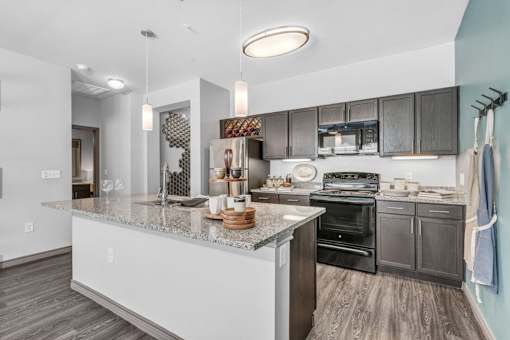 A modern kitchen with dark wood cabinets and a granite countertop.