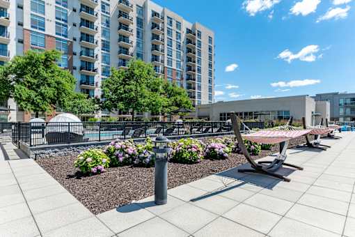 A modern outdoor seating area with benches and a fountain in front of apartment buildings.