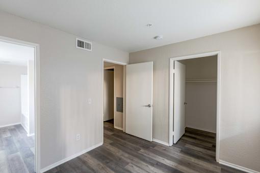 the living room of an apartment with wood floors and white walls
