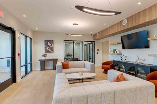 Community lobby with comfortable seating, stylish lighting fixtures, and a media wall at Creekline at Fairfield, Fairfield CT.