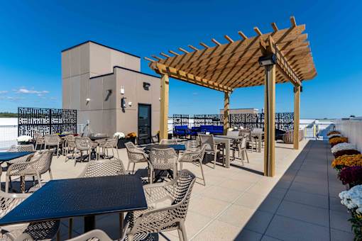 Rooftop patio with shaded pergola, outdoor tables, and resident gathering space at Creekline at Fairfield, Fairfield CT.