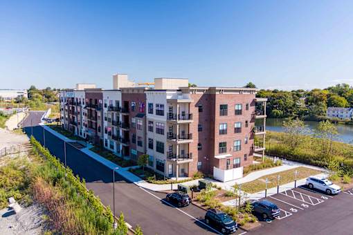 Aerial view of the apartment community exterior with balconies and waterfront scenery at Creekline at Fairfield, Fairfield CT.