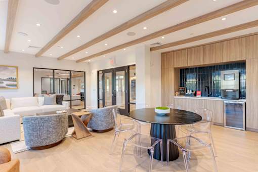 Resident lounge at Creekline at Fairfield apartments in Fairfield, CT featuring cozy seating, a community kitchenette, and a coffee/espresso machine station.