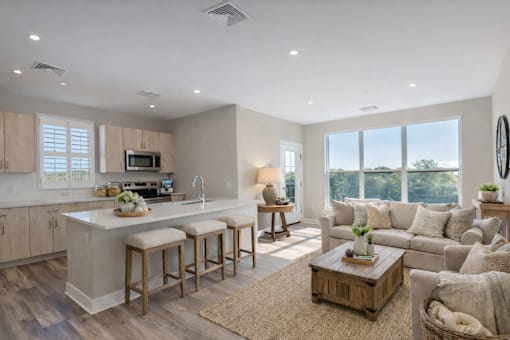 Bright open-concept kitchen and living area at Creekline at Fairfield apartments in Fairfield, CT, featuring light wood cabinetry