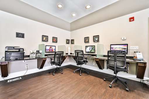 Apartments in Geneva, IL for Rent- Ashford at Geneva-  A room with a long desk and chairs with a computer on it.