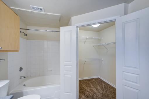 A white bathroom with a tub, toilet, and sink.
