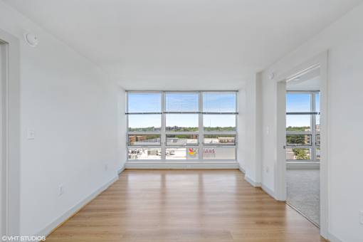 A large empty room with a view of the outside through the windows.