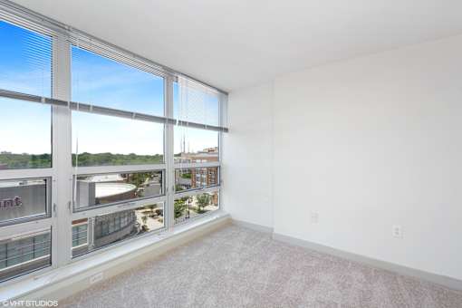 A large empty room with a view of the city through the windows.