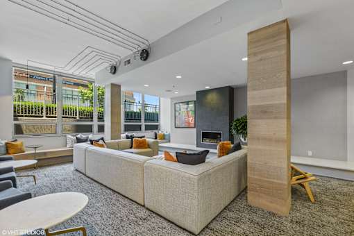 A modern living room with a large sectional sofa and a wooden pillar.