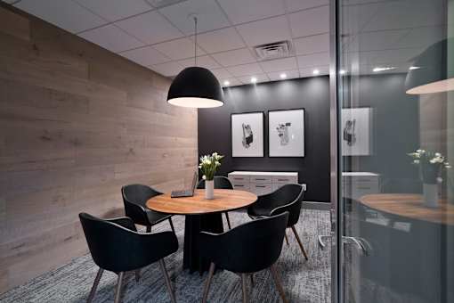 A modern dining room with a round table and chairs.