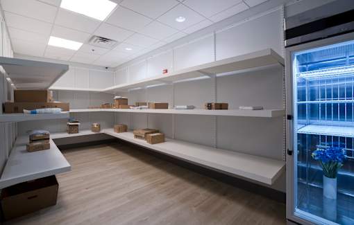 A storage room with shelves and boxes on the floor.