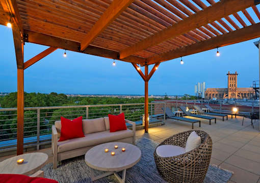 A wooden patio with a couch, table, and chairs.