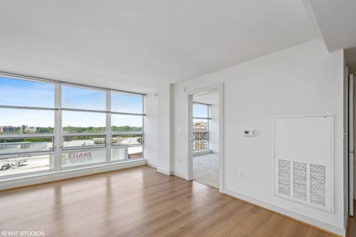 A room with a large window overlooking a parking lot.