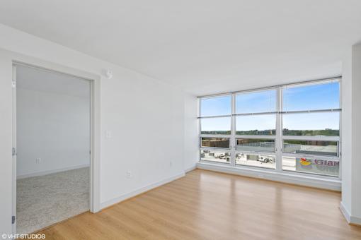A large empty room with a view of a parking lot outside.