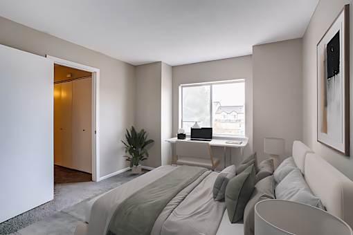 A bedroom with a bed, desk, and chair.