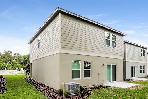 A modern house with a grey siding exterior and a green door.