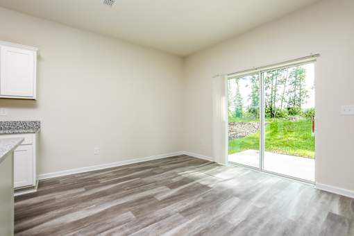 A room with a sliding glass door leading to a garden.
