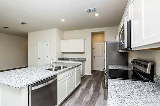 A kitchen with granite countertops and stainless steel appliances.