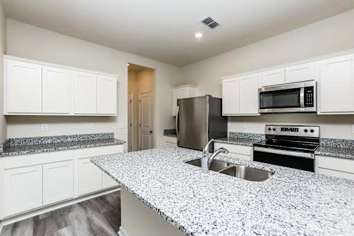 A kitchen with granite countertops and stainless steel appliances.