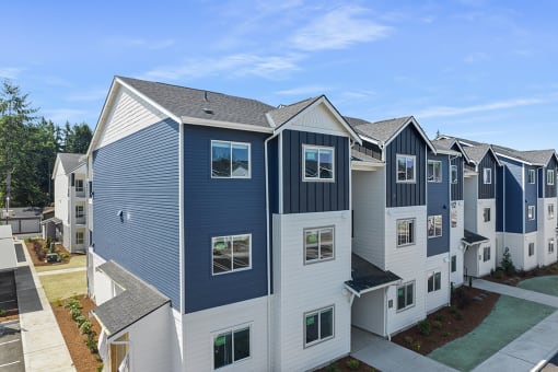 an aerial view of a row of multifamily buildings with blue and white siding,