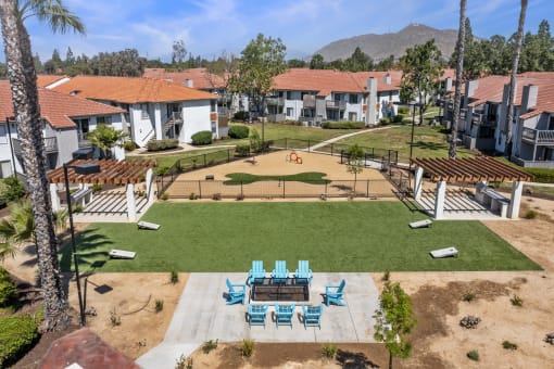 One Bedroom Apartments In Moreno Valley, CA - Ardella On Chagall - An Aerial View Of A Community Dog Park With A Bone-Shaped Turf Area, Adjacent To A Fire Pit And Lawn Games.