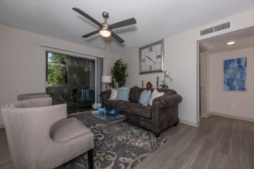 Lawrenceville, GA Apartments – Park on Sweetwater – a living room with a ceiling fan and a couch