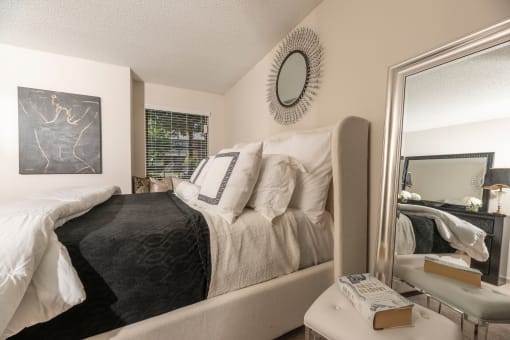 Lawrenceville, GA Apartments – Park on Sweetwater – spacious bedroom with a large mirror and a bed with white and black pillows and