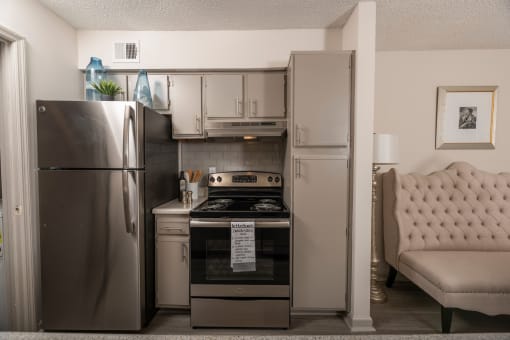 Lawrenceville, GA Apartments – Park on Sweetwater – a kitchen with stainless steel appliances and a stainless steel refrigerator
