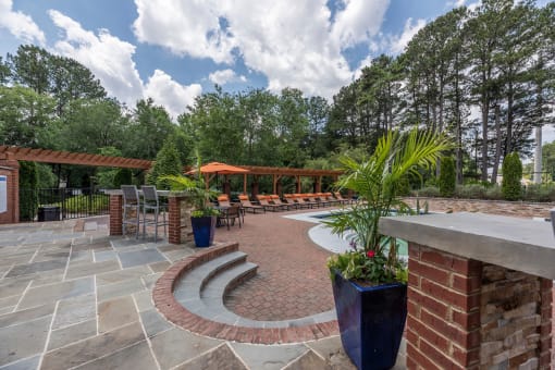 Lawrenceville, GA Apartments – Park on Sweetwater – a patio with brick pillars and a seating area with potted plants