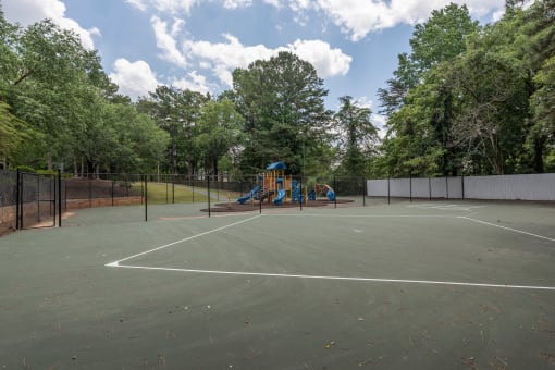 Apartments For Rent In Lawrenceville, GA - Park On Sweetwater Apartments - Outdoor Fenced-In Tennis Court Next To Playground