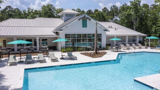Pet-Friendly Apartments in Savannah, GA – The Palms at Chatham – a swimming pool with chaise lounge chairs and umbrellas