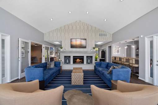 A living room with a fireplace and blue couches.
