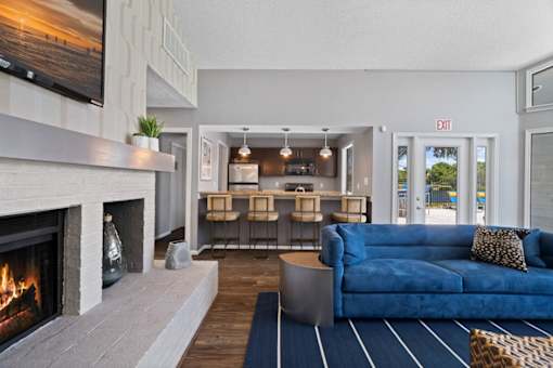 A living room with a fireplace and a blue couch.