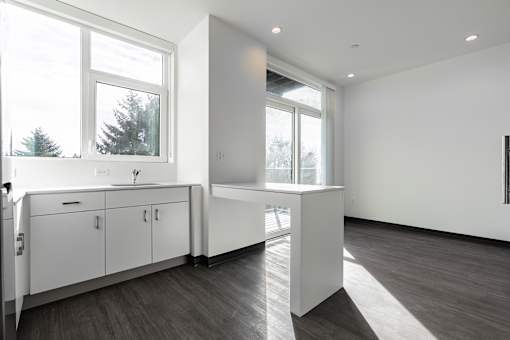 A kitchen with white cabinets and a large window.