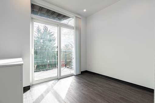 A room with a white wall and a sliding glass door.