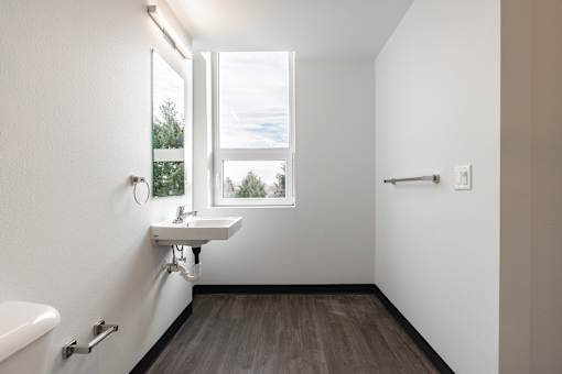 A white sink in a bathroom with a window.