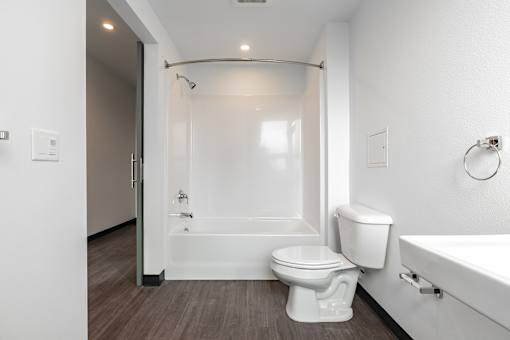 A white bathroom with a toilet, sink, and bathtub.